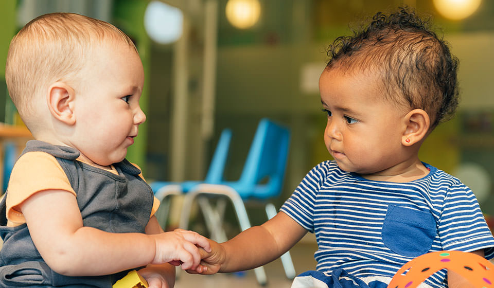 Infants holding hands