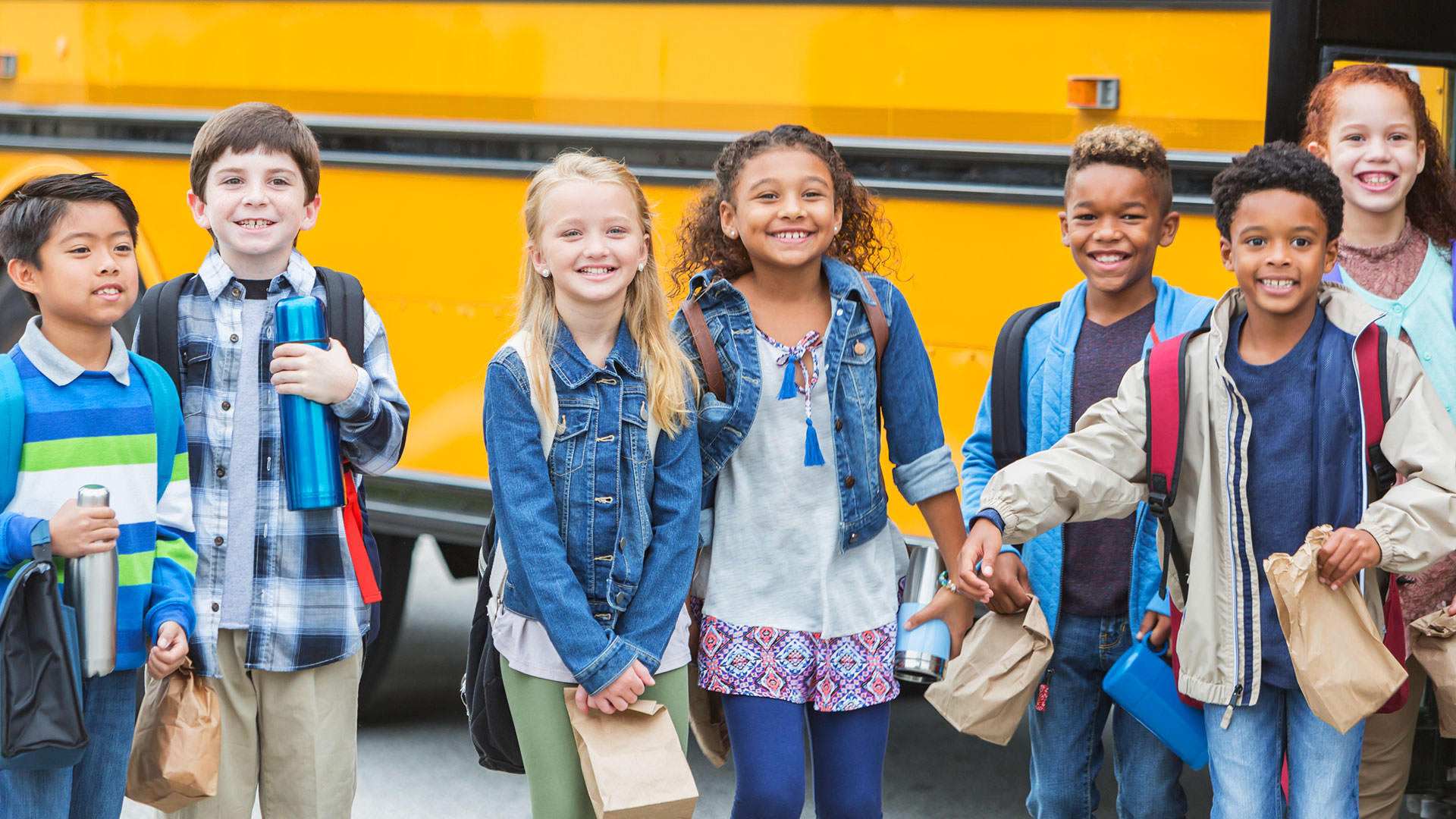 Children standing in front of bus