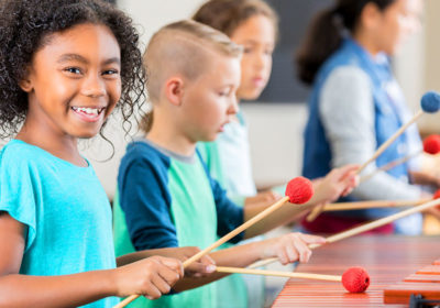 School age kids playing xylophone