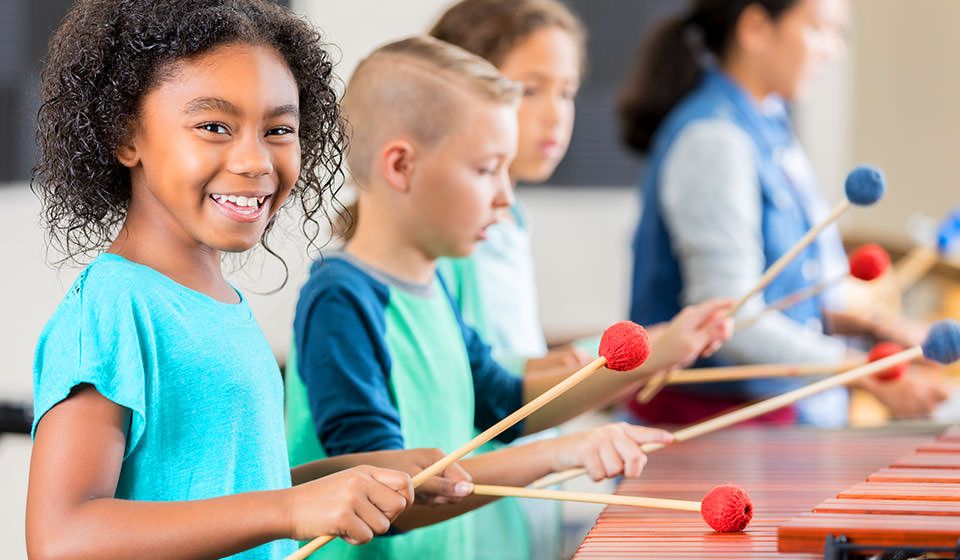 School age kids playing xylophone